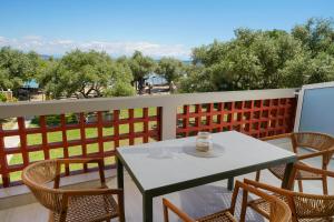 a table and chairs on a balcony with a view at Kalliston Beach Apartments in Limenas