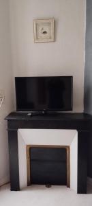 a black and white fireplace with a flat screen tv at Villa Mon Repos 2 in La Bourboule