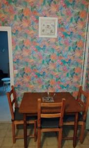 a table with two chairs and a flowery wall at Villa Mon Repos 2 in La Bourboule +7 photos