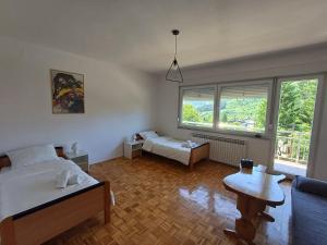 a bedroom with a bed and a couch and a table at BIKER'S BASE Guesthouse in Jajce +7 photos