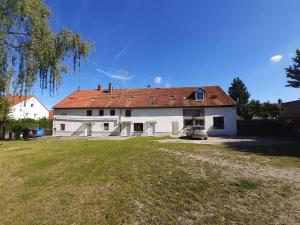 a white house with a red roof and a yard at 2-Rent Group Hostel Rooms&Apartments EVE168 in Munich