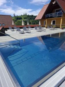 una grande piscina con sedie e un edificio di Nussberg Chalet a Ehrenhausen