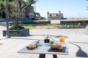 a table with croissants and coffee and orange juice at San Gennaro House in Pozzuoli