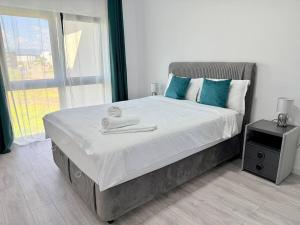 a bedroom with a large bed with towels on it at Euphoria Apartment VRT in Sibiu