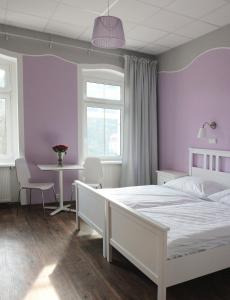 a bedroom with a white bed and a table at Hotel Orix in Jáchymov