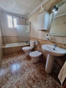 ein Badezimmer mit 2 WCs, einem Waschbecken und einer Badewanne in der Unterkunft Amanecer Costero in Orihuela