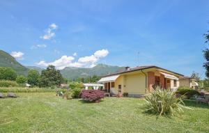 une petite maison dans une cour avec des montagnes en arrière-plan dans l'établissement Stunning Home In Camaiore With Wifi, à Camaiore