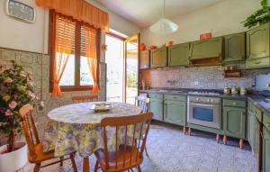 une cuisine avec des armoires vertes et une table avec des chaises dans l'établissement Stunning Home In Camaiore With Wifi, à Camaiore