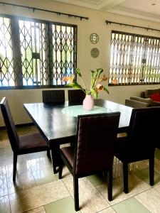 a dining room with a table and chairs and a couch at Refined Comfort at the Right Price-Four Bedroom Luxury Apartment in Accra