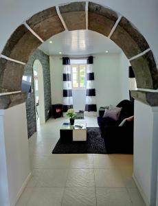 an archway in a living room with a couch and a table at The Cedar Tree House in Sete Cidades +11 photos