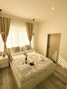 um quarto com uma cama com uma garrafa de vinho em cima em VIBE S32 Apartman,AC,Free Parking em Székesfehérvár