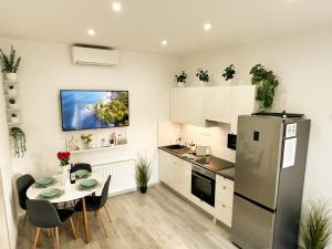 a kitchen with a table and a refrigerator at VIBE S32 Apartman,AC,Free Parking in Székesfehérvár