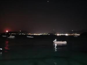a boat in a body of water at night at ABEAS Studios 2 in Avlákia +2 photos