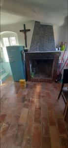una sala de estar con chimenea y una cruz en la pared en Casa valeriano, en Valeriano Lunense