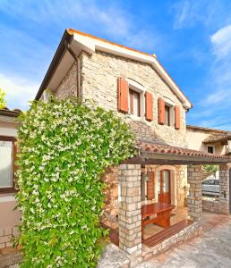 a stone house with a bench in front of it at Apartmani Petar Stojnić in Vabriga