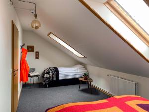 a attic bedroom with a bed and a dress on a table at KEX Þingeyri in Þingeyri