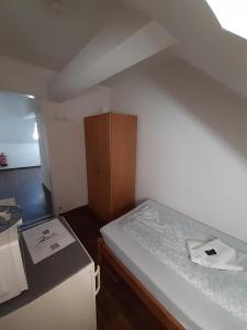 a small room with a small bed and a kitchen at 2-Rent Group Hostel Rooms&Apartments EVE168 in Munich +97 photos