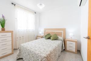 a white bedroom with a bed with two green pillows at Casa con Terraza y Parking en el Centro By Aloha Palma in Águilas