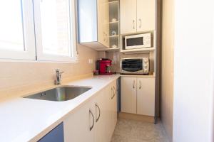 a kitchen with a sink and a microwave at Casa con Terraza y Parking en el Centro By Aloha Palma in Águilas