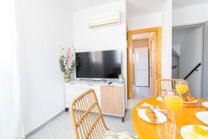 a dining room with a table and chairs and a television at Casa con Terraza y Parking en el Centro By Aloha Palma in Águilas +30 photos