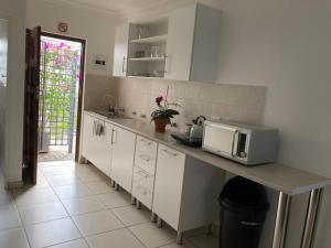a kitchen with a counter top with a microwave at Montana Cape House in Pretoria