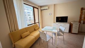 una sala de estar con un sofá y una mesa en One bedroom Apartment, en Sunny Beach