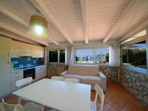 a kitchen and living room with a table and a couch at Marinella Beach Apartments - On The Beach - Private Free Parking in Capo Vaticano