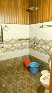 a bathroom with a shower and a toilet and a bucket at Hotel Sandalwood in Amritsar