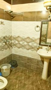 a bathroom with a sink and a toilet and a mirror at Hotel Sandalwood in Amritsar