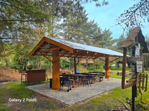 a pavilion with tables and chairs in a park at Bike Camping in Przewóz