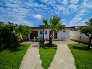 a house with palm trees in the yard at Marinella Beach Apartments - On The Beach - Private Free Parking in Capo Vaticano