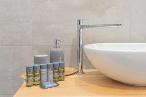 un bagno con lavandino e bottiglie di oli essenziali di Independence Apartment with Balcony by Rent All Como a Como Altre 28 foto