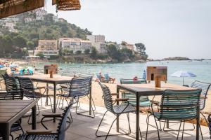 a group of tables and chairs on a beach at Canyelles Platja in Roses