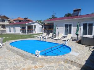 a swimming pool with lounge chairs at Къщи за гости "Ямира" in Banya