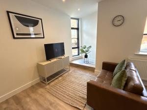 un salon avec un canapé et une télévision à écran plat dans l'établissement Luxury 1 bed - 6 Queen Street Abingdon - Centrally located parking subject to availability, à Abingdon