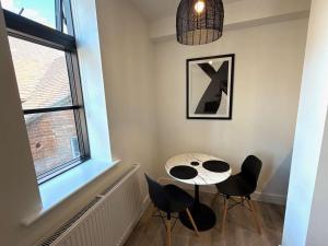 une pièce avec une table, des chaises et une fenêtre dans l'établissement Luxury 1 bed - 6 Queen Street Abingdon - Centrally located parking subject to availability, à Abingdon