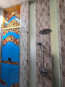 a shower with a blue door in a bathroom at Studio Guesthouse No 39 in Lovina +11 photos
