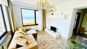 a living room with a couch and a tv at Summerland Studios Nuba in Mamaia