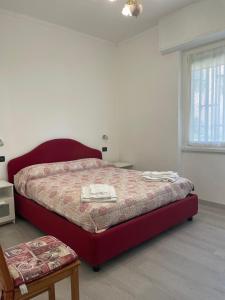 a bedroom with a red bed and a window at Casa Gelsomina apartment in Rapallo
