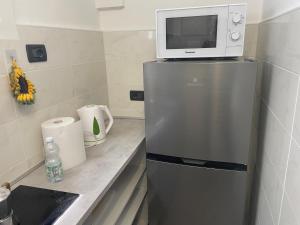 a microwave on top of a refrigerator in a kitchen at Casa Gelsomina apartment in Rapallo +9 photos