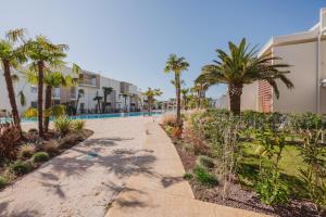 a pathway with palm trees in front of a building at Wave Island A15 in Lido di Jesolo