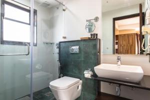 ein Badezimmer mit Waschbecken, Toilette und Dusche in der Unterkunft Hotel Kutumba in Pātan