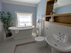 チチェスターにあるGeorgian House - Great for Groups & Celebrations! Located in Central Chichester with Parking - Chichester Holiday Propertiesの洗面台、浴槽、トイレを備えたバスルーム +69枚の写真