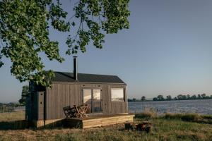 a tiny house with a bench in a field at TerraCabins - Malagueiro in Benavente +35 photos