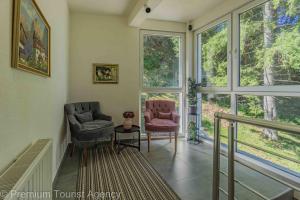a living room with two chairs and large windows at Hotel Central Vlasic in Vlasic +78 photos