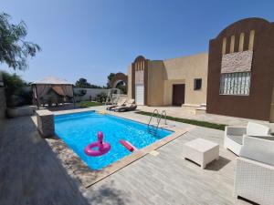 a swimming pool with two inflatable flamingos in it at Villa lucky in Hammamet