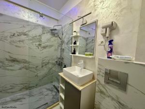 a bathroom with a sink and a glass shower at Seaview Studio in Năvodari +21 photos