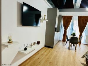 a living room with a table and a television on a wall at Seaview Studio in Năvodari