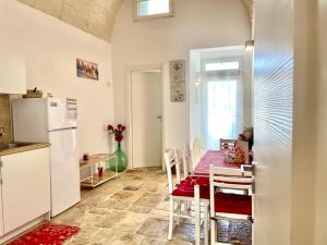 a kitchen with a table and a refrigerator at Antica Pietra in Polignano a Mare