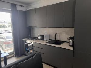 Una cocina con fregadero, estufa y microondas. en Apartament Camy - Meraki Resort & SPA, en Mamaia Nord – Năvodari